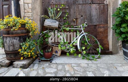 Vélo ancien et décoratif penchant contre la vieille porte en bois du village traditionnel en Espagne Banque D'Images