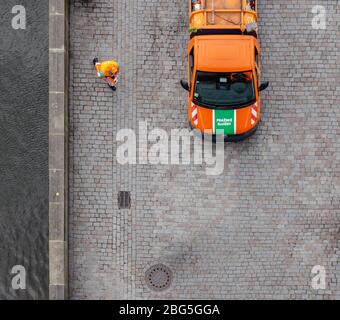 Vue depuis le sommet de la tour du pont de la vieille ville d'un camion à ordures Pražské služby (Prague services) en attente et travailleur en action à Prague, République tchèque. Banque D'Images