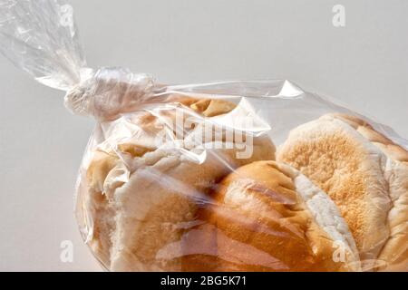 Trois petits pains dans un sac en plastique. Pain emballé en plastique transparent sur fond clair avec espace de copie. Zéro gaspillage, sans plastique. Banque D'Images