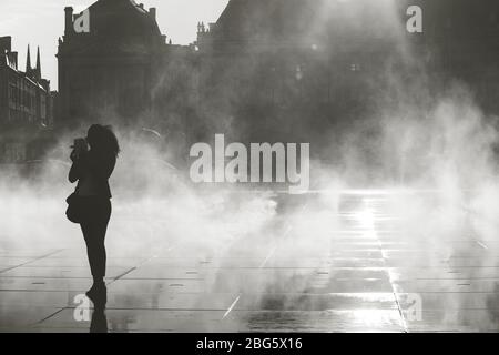 Silhoette de femme prenant photo sur miroir d'eau à Bordeaux, France Banque D'Images