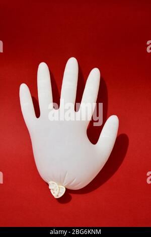 Gants médicaux blanc isolé sur fond rouge. Protection Banque D'Images