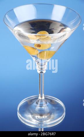 Martini avec des olives vertes sur fond bleu Banque D'Images