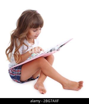 Petite fille assise sur le plancher avec livre isolé sur blanc Banque D'Images