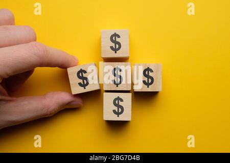 Concept d'économie d'argent et d'économie - cubes en bois avec signe dollar à la main. Gros plan. Banque D'Images