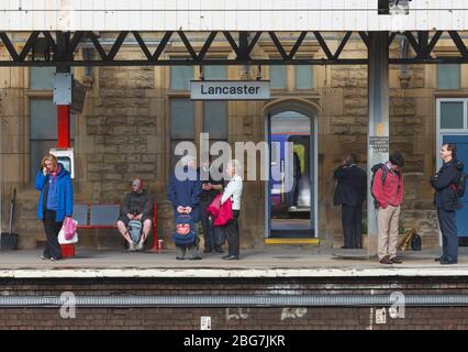 Les passagers à la gare de Lancaster sur la ligne principale de la côte ouest attendent un train Banque D'Images