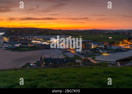 West Bay, Dorset, Royaume-Uni. 20 avril 2020. Météo britannique. Le ciel brille de shorty orange après le coucher du soleil à la station balnéaire de West Bay à Dorset avec le temps réglé pour continuer cette semaine avec des températures croissantes. Crédit photo : Graham Hunt/Alay Live News Banque D'Images