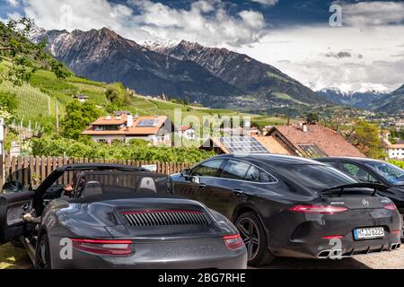 Italie, Trentin, 29 avril 2019: Panneaux solaires sur le toit à travers les voitures de luxe les plus puissantes, montagnes Dolomites en arrière-plan, d'énormes nuages Banque D'Images