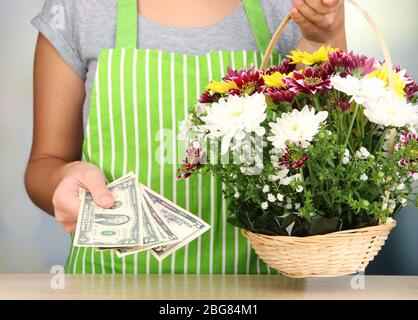 Le fleuriste fait du bouquet de fleurs dans un panier en osier Banque D'Images