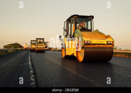 rouleau de route appliquant une nouvelle surface d'asphalte. Chantier de construction de revêtement d'asphalte sur une route Banque D'Images