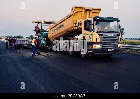 travailleurs de la construction de routes qui travaillent sur des chaussées. entretien des routes, machine d'asphalte qui pond de nouveaux asphalte ou bitume lors de la construction de routes Banque D'Images