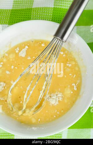 Corolle et œufs cassés avec farine dans un bol sur le gros plan de la nappe Banque D'Images