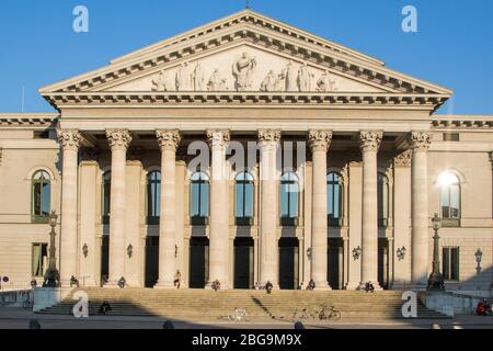 Les gens bronzer sur les colonnes de l'escalier menant à l'Opéra d'État bavarois, Max-Joseph-Platz, Munich, Bavière, Allemagne Banque D'Images