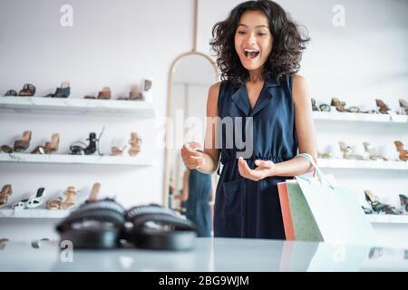 enchanté a surpris les femmes asiatiques qui font du shopping en regardant des chaussures dans les rayons de la boutique Banque D'Images