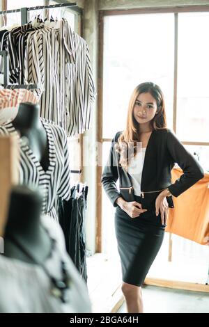 Belle femme portant de beaux vêtements, posant sur la boutique de mode Banque D'Images