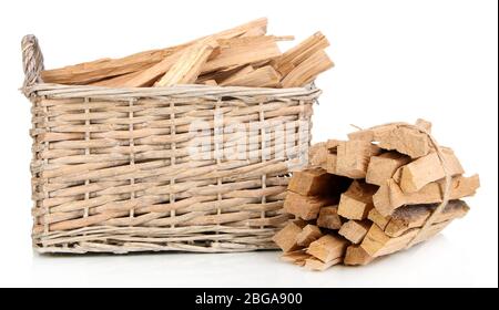 Pile de bois de chauffage dans un panier en osier isolé sur blanc Banque D'Images