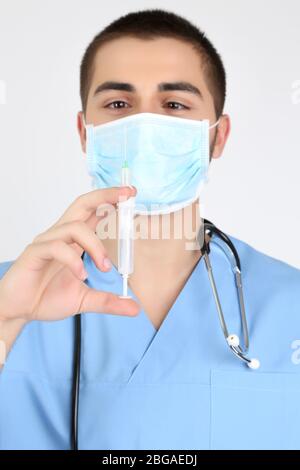 Médecin jeune homme dans un masque médical, isolé sur blanc Banque D'Images