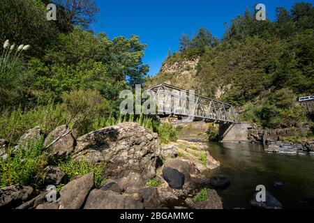 Pont ferroviaire au-dessus de la rivière Ohinemuri près de l'entrée du tunnel ferroviaire de Karangahake sur la piste ferroviaire de Hauraki, île du Nord, Nouvelle-Zélande Banque D'Images