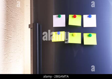 Vider les feuilles de papier et les aimants colorés sur la porte du réfrigérateur Banque D'Images