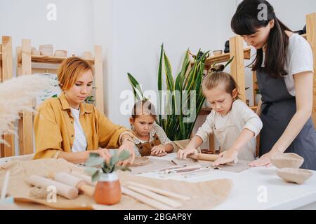 Femme et son groupe d'apprentissage travaillant avec l'argile dans un atelier Banque D'Images