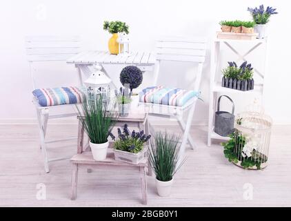 Chaises de jardin et table avec fleurs sur des supports en bois sur fond blanc Banque D'Images