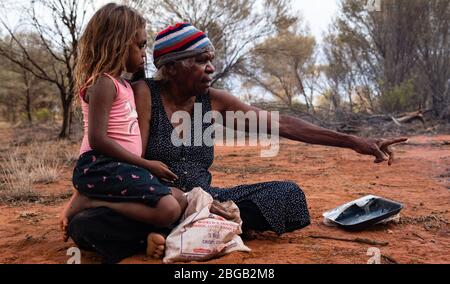 Yuendumu, NT Australie, février 15 2020 : Aborigènes Warlpiri dans le Bush. Famille, grand-mère et petite-fille, après avoir chassé des fourmis de miel Banque D'Images