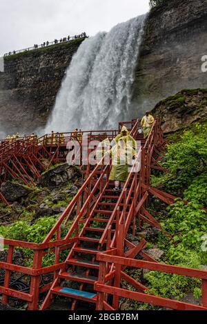 Chutes Niagara, NY, États-Unis - 13 juin 2019 : les visiteurs des manteaux de pluie dans un escalier en bois humide font une visite sous les éclaboussures des chutes américaines Banque D'Images