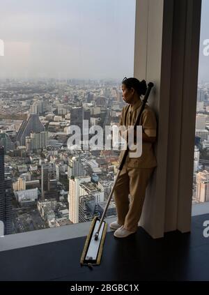 Bangkok, Thaïlande - 29 février 2020 : un gratte-ciel plus propre prend un moment pour profiter du paysage urbain de Bangkok au crépuscule. Banque D'Images