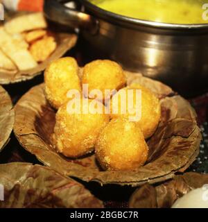 Les sucreries traditionnelles indiennes Besan Laddu sont servies dans une assiette jetable à feuilles sèches avec des bonbons indiens typiques, une rue délicieuse de style villageois pur Banque D'Images