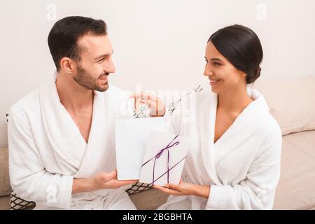 Un beau couple a reçu des cadeaux du spa pour être des clients réguliers. L'homme et la femme portent des peignoirs vides pour le spa Banque D'Images