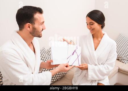 Un beau couple a reçu des cadeaux du spa pour être clients réguliers. Spa et complexe. Homme et femme portant des peignoirs de bain vides Banque D'Images