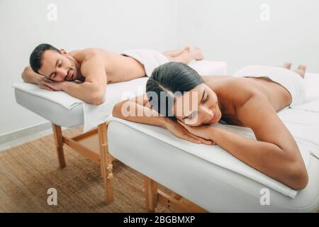 Belle femme a fermé les yeux avec plaisir tout en se relaxant avec son petit ami dans un salon de spa. Couple après massage Banque D'Images