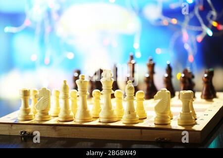 Pièces des échecs à bord sur fond lumineux Banque D'Images