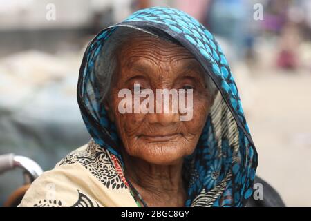 Dhaka, Bangladesh. 20 avril 2020. Une vieille femme en fauteuil roulant attend de recueillir des secours alimentaires au milieu de la crise du COVID -19 Coronavirus.A l'initiative de M. Mohammad Mazharul Islam Sentu, président de la Mosquée du Kamalapur-Jame du Sud, des secours alimentaires sont distribués chaque jour depuis le 26 mars. Crédit: SOPA Images Limited/Alay Live News Banque D'Images