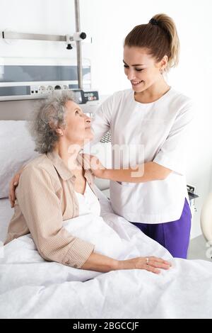 Une femme atteinte de la maladie d'Alzheimer qui repose au lit reçoit des soins infirmiers. Traiter et prendre soin des personnes âgées atteintes de la maladie d'Alzheimer Banque D'Images