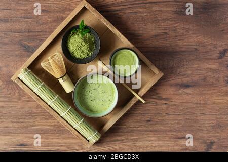 Thé vert matcha biologique et accessoires de thé sur plateau avec vue sur table en bois. Concept de cérémonie du thé japonais. Alimentation saine, désintoxication. Banque D'Images