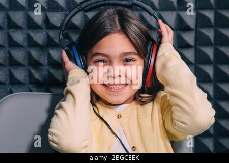 Joli petit enfant de course mixte pendant l'examen d'audition de la procédure. Fille portant un casque spécial pour obtenir le test auditif, l'audiométrie Banque D'Images