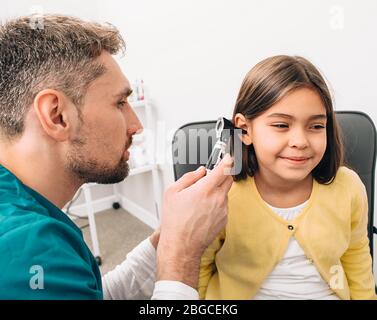 Pédiatre examinant peu de race mixte enfant avec otoscope, examen auditif de l'enfant Banque D'Images