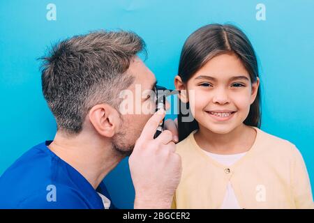 Pédiatre examinant peu de race mixte enfant avec otoscope, examen auditif de l'enfant Banque D'Images