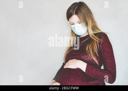 Jeune femme enceinte portant un masque facial Banque D'Images