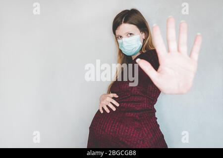 Jeune femme enceinte portant un masque facial Banque D'Images