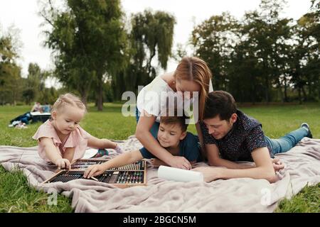 Famille, mère, père, fils et fille adorables passent du temps ensemble, s'inspirant de la nature posée sur la couverture Banque D'Images