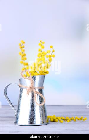 Brindilles de fleurs mimosa dans vase sur table en bois Banque D'Images