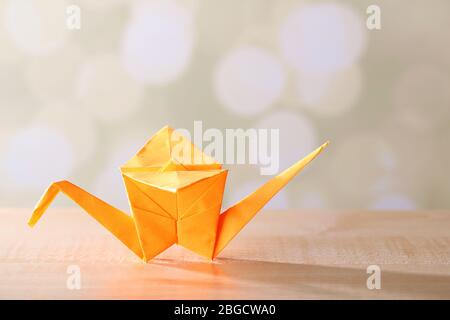 Grue Origami sur table en bois, sur fond clair Banque D'Images