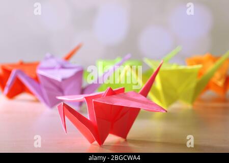 Grues Origami sur table en bois, sur fond clair Banque D'Images