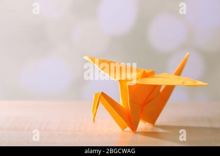 Grue Origami sur table en bois, sur fond clair Banque D'Images