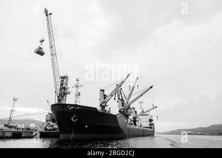 Chargement d'un transporteur en vrac dans le port de Varna, Bulgarie. Noir et blanc Banque D'Images