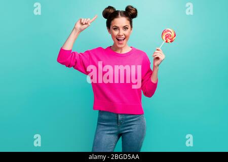 Portrait de sa belle jolie jolie jolie fille enlisée à poil ondulé et gaie tenue à la main lolli-pop montrant de nouvelles cheveux isolés sur brillant Banque D'Images