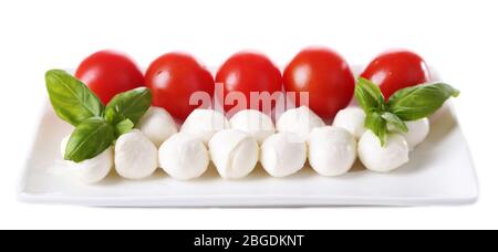 De délicieuses boulettes de mozzarella au basilic et aux tomates rouges, isolées sur blanc Banque D'Images