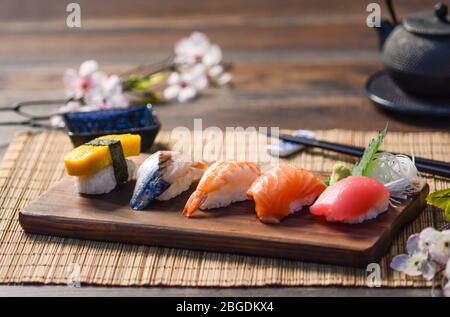 Mélanger les sushis sur le plat à bois, le thon, le saumon, le bar de mer, l'œuf sucré, Sushis aux crevettes, cuisine japonaise. Plats japonais sur l'assiette. Banque D'Images