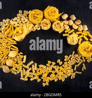 Motif sq de pâtes italiennes avec espace publicitaire, une couche plate de divers types de pâtes, tiré d'en haut sur un fond noir Banque D'Images